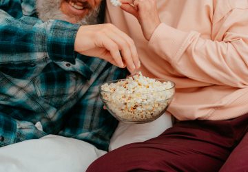 Husband and wife watch a film on the bed